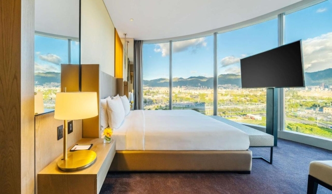 Una gran habitación del Grand Hyatt de Bogotá, Colombia, con ventanales envolventes con vistas a la ciudad ya las montañas.