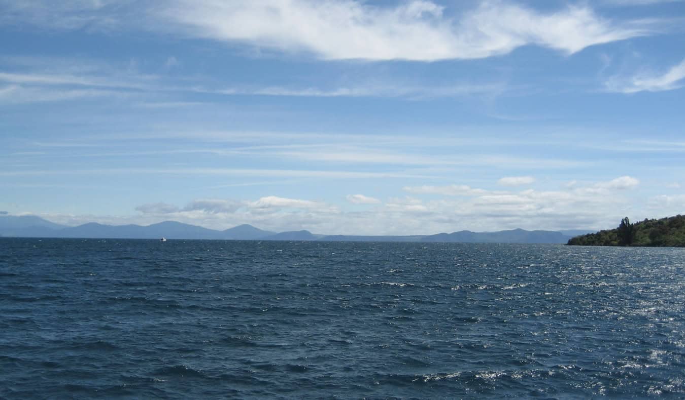 El sereno lago de Taupo con montañas al fondo, en Nueva Zelanda